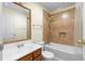 Bathroom with tiled tub and shower combo, wood vanity, and framed mirror at 1920 Jett Ridge Rd, Cumming, GA 30041