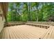 Large wooden deck with built-in seating surrounded by lush greenery and mature trees at 1920 Jett Ridge Rd, Cumming, GA 30041