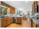 Well-lit kitchen features stainless appliances, wood cabinets, and a view of the dining area at 1920 Jett Ridge Rd, Cumming, GA 30041