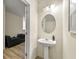 Cozy half bathroom featuring a pedestal sink, decorative mirror, and neutral wall color at 3379 Thornbridge Dr, Powder Springs, GA 30127
