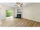 Bright living room featuring wood-look floors, a fireplace, and sliding glass doors to the backyard at 3379 Thornbridge Dr, Powder Springs, GA 30127