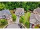 Aerial view of a home showcasing its well-manicured lawn, mature trees, and proximity to neighboring properties at 4779 Bogan Meadows Dr, Buford, GA 30519