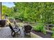 A backyard featuring a playset, fire pit with chairs, and lush landscaping, perfect for outdoor entertaining and relaxation at 4779 Bogan Meadows Dr, Buford, GA 30519