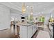 Open kitchen with granite countertops, an island, stainless steel appliances, and hardwood floors that lead to the living room at 4779 Bogan Meadows Dr, Buford, GA 30519