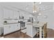 Bright kitchen featuring white cabinets, stainless steel appliances, a kitchen island with granite countertops, and hardwood floors at 4779 Bogan Meadows Dr, Buford, GA 30519