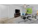 Living room featuring comfortable couches, a modern TV with a dark entertainment center, and an exercise bike by the window at 4779 Bogan Meadows Dr, Buford, GA 30519