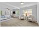 Spacious main bedroom featuring a ceiling fan, natural light, light walls, carpeted floors, and two comfortable sitting chairs at 4779 Bogan Meadows Dr, Buford, GA 30519