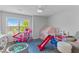 Bright playroom with large window, gray walls, and assorted toys including a slide and ball pit at 4779 Bogan Meadows Dr, Buford, GA 30519