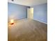 A bedroom with carpeted floors and blue painted walls and a door leading to a hallway at 6005 Pattingham Dr, Roswell, GA 30075