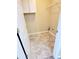 This is a laundry room with white painted walls, tile floors, and cabinets above for storage at 6005 Pattingham Dr, Roswell, GA 30075
