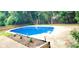 Sparkling in-ground pool with concrete surround and wooden perimeter fence at 6005 Pattingham Dr, Roswell, GA 30075