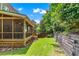 Screened porch leading to a beautifully landscaped backyard with lush green grass at 1085 Highland Crest Ct, Mableton, GA 30126