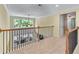 Upstairs hallway with carpet flooring, black metal railing, and views of the living room at 1085 Highland Crest Ct, Mableton, GA 30126