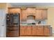 Kitchen featuring stainless steel refrigerator, wood cabinetry, granite countertops, and hardwood floors at 1085 Highland Crest Ct, Mableton, GA 30126