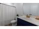 Bathroom featuring a toilet, navy vanity with gold hardware, a shower with a curtain, and a mirror at 1624 Gunnin Nw Trce, Atlanta, GA 30318