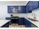 This modern kitchen includes stainless steel appliances, quartz countertops and navy cabinets at 1624 Gunnin Nw Trce, Atlanta, GA 30318