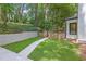 Landscaped backyard with a walkway leading to a private area, featuring lush grass and a stone retaining wall at 2858 Mornington Nw Dr, Atlanta, GA 30327