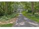 View of the long driveway leading to a house surrounded by mature trees and lush greenery at 2858 Mornington Nw Dr, Atlanta, GA 30327