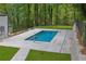 A backyard rectangular pool is surrounded by stone and lush greenery, offering a serene retreat at 2858 Mornington Nw Dr, Atlanta, GA 30327