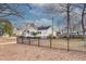 A view of the home's side exterior, a black iron fence, and surrounding trees at 332 Shadowmoor Dr, Decatur, GA 30030
