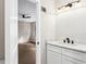 Bathroom with marble countertop, white cabinets, bronze fixtures and view into an adjacent bedroom with ceiling fan at 3589 Hopkins Ct, Powder Springs, GA 30127
