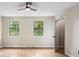 Sunlit bedroom with wood-look flooring, neutral paint, two windows, and modern ceiling fan at 3589 Hopkins Ct, Powder Springs, GA 30127