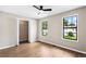 A bedroom featuring modern ceiling fan, wood-look floors, closet, and two windows with neighborhood views at 3589 Hopkins Ct, Powder Springs, GA 30127