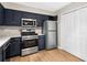 View of the updated kitchen with stainless steel appliances, including a double-door pantry at 3589 Hopkins Ct, Powder Springs, GA 30127