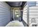 Stylish covered entryway with gray siding, a glass front door with sidelights, and decorative outdoor accents at 2190 Ashley Crossing Ct, Lawrenceville, GA 30043
