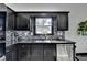Modern kitchen features sleek black cabinets, mosaic backsplash, stainless steel appliances, and a bright window at 2190 Ashley Crossing Ct, Lawrenceville, GA 30043