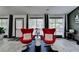 Cozy seating area featuring two red modern chairs, plenty of natural light, and sleek wood flooring at 2190 Ashley Crossing Ct, Lawrenceville, GA 30043