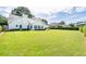 Expansive backyard featuring a lush lawn, hedges, and a charming white house at 3027 Biltmore Woods Dr, Buford, GA 30519