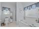 Bright bathroom featuring a soaking tub, a glass-door shower, and storage shelves at 3027 Biltmore Woods Dr, Buford, GA 30519