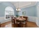 Elegant dining room with wainscoting, chandelier, arched window, and a hardwood dining table with seating for six at 3027 Biltmore Woods Dr, Buford, GA 30519