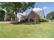 Brick home featuring a manicured lawn, mature trees, and charming curb appeal in a serene suburban setting at 3027 Biltmore Woods Dr, Buford, GA 30519