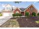 Charming brick two-story home with manicured lawn, mature trees, and attached garage, perfect for suburban living at 3027 Biltmore Woods Dr, Buford, GA 30519
