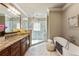 A spa-like main bathroom features a soaking tub, glass shower, and granite-topped vanity at 567 N Palisades Se Cir, Marietta, GA 30067