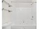 Bathroom featuring a soaking tub with a shower head and sleek, white tiling at 5529 Festival Ave, Fairburn, GA 30213