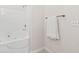 Bathroom features a sleek soaking tub with shower head, and white towel at 5529 Festival Ave, Fairburn, GA 30213