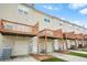 Exterior view of townhomes with individual garages, decks, and beige siding at 5529 Festival Ave, Fairburn, GA 30213