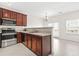Bright kitchen with stainless steel appliances, dark wood cabinets, and laminate flooring at 5529 Festival Ave, Fairburn, GA 30213