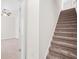 Carpeted staircase with white trim is adjacent to a room with a ceiling fan and a glimpse of a bright space at 5529 Festival Ave, Fairburn, GA 30213