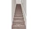 Carpeted staircase with white railings leads to the upper level, providing a seamless transition between floors at 5529 Festival Ave, Fairburn, GA 30213
