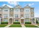Charming multi-story townhouse with stone and siding exterior, complemented by well-manicured landscaping at 5529 Festival Ave, Fairburn, GA 30213