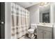 Cozy bathroom with modern white vanity, toilet and a shower-tub featuring a striped curtain at 6086 Willowpond Ct, Douglasville, GA 30135