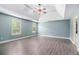 Spacious main bedroom with a tray ceiling, hardwood-style floors, and two windows at 6086 Willowpond Ct, Douglasville, GA 30135