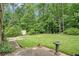 Backyard featuring an extensive lawn, mature trees, storage shed, and bird bath at 757 Tall Deer Dr, Fairburn, GA 30213