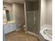 An en suite bathroom with a double sink vanity, shower, soaking tub and tile flooring at 125 Villa Park Cir, Stone Mountain, GA 30087