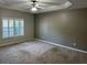 A bedroom featuring neutral walls, carpet, ceiling fan and a window with shutters at 125 Villa Park Cir, Stone Mountain, GA 30087