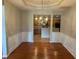 Inviting dining room featuring elegant wainscoting, hardwood floors, and a stylish chandelier at 125 Villa Park Cir, Stone Mountain, GA 30087